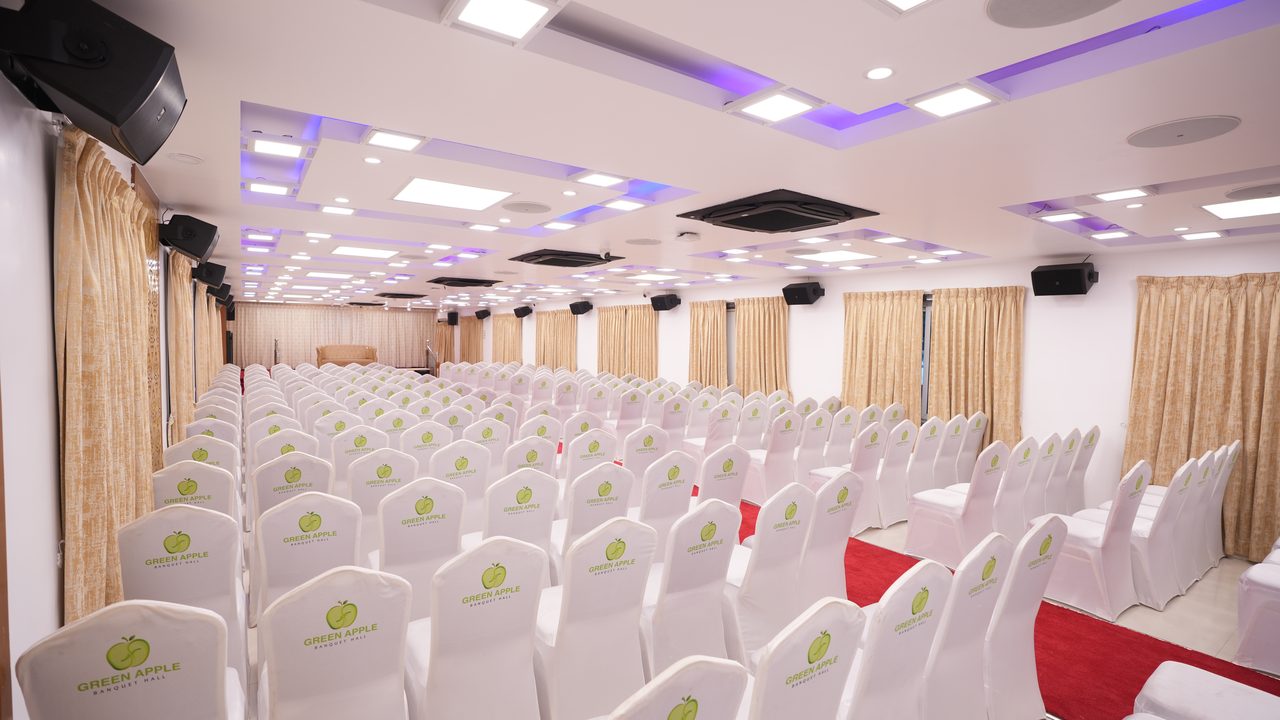 Rows of white chairs beside the red-carpet aisle